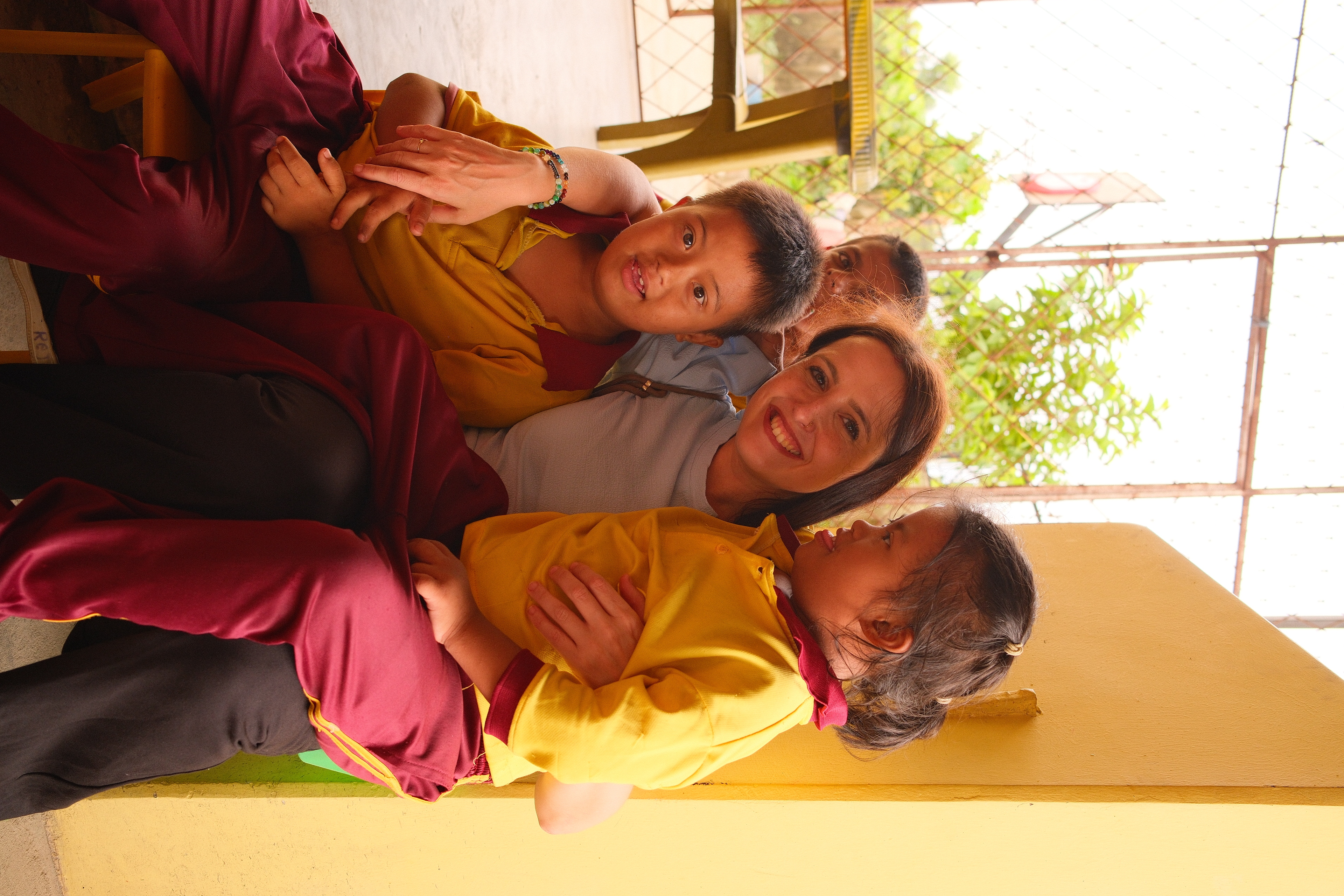 A woman smiling with three children at Si Asha Foundation